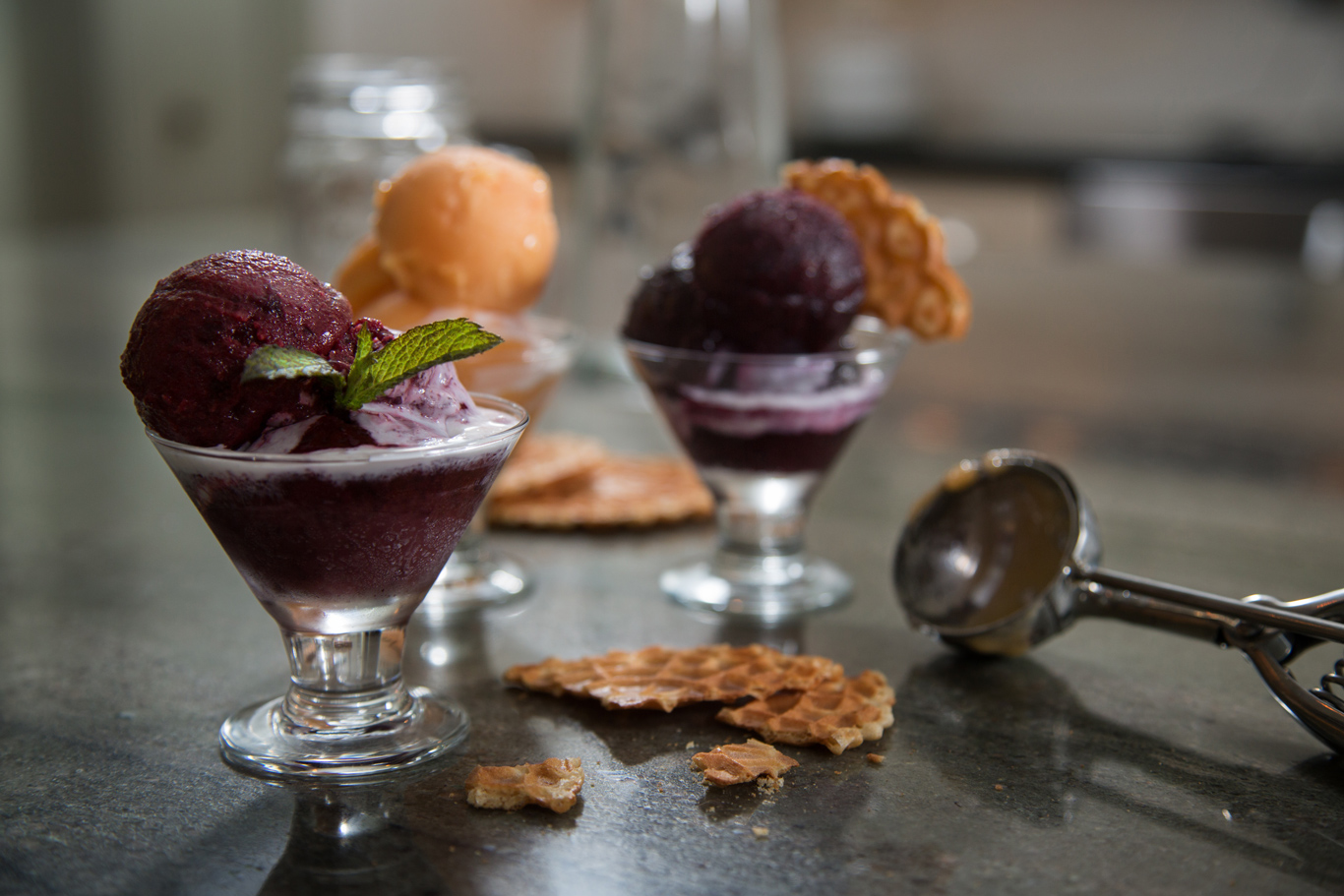 Berry and Orange sorbet with mint and waffle cone, in a nice kitchen.